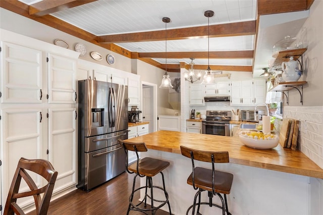 kitchen featuring beamed ceiling, wood counters, and stainless steel appliances