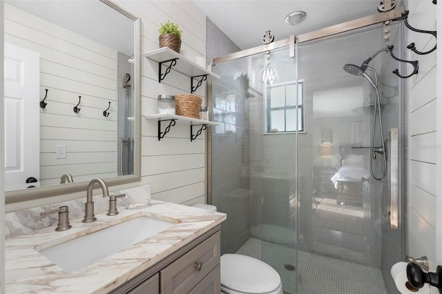 bathroom featuring toilet, vanity, and an enclosed shower