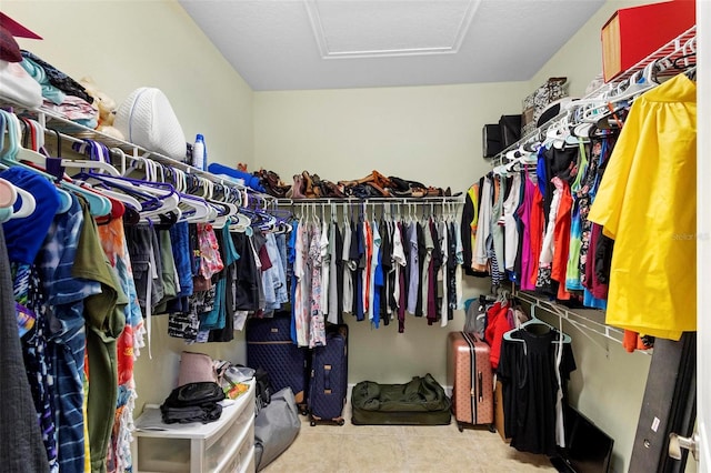 walk in closet featuring tile patterned flooring and attic access