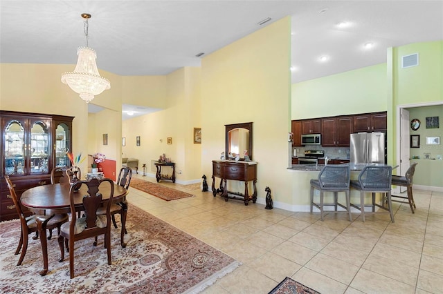 dining area with high vaulted ceiling, light tile patterned flooring, visible vents, and an inviting chandelier