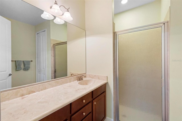 bathroom featuring a stall shower, a notable chandelier, and vanity