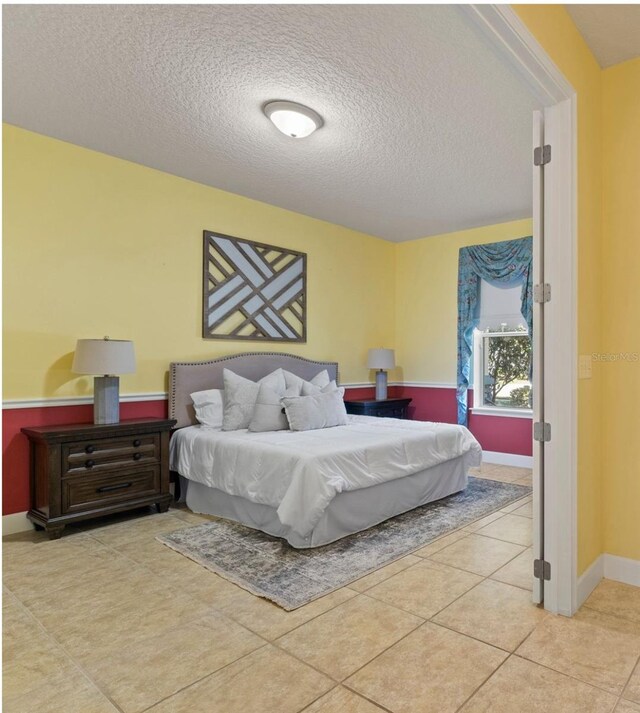 309 Chesham St, Ormond Beach, FL 32174 - tiled bedroom featuring a textured ceiling and baseboards