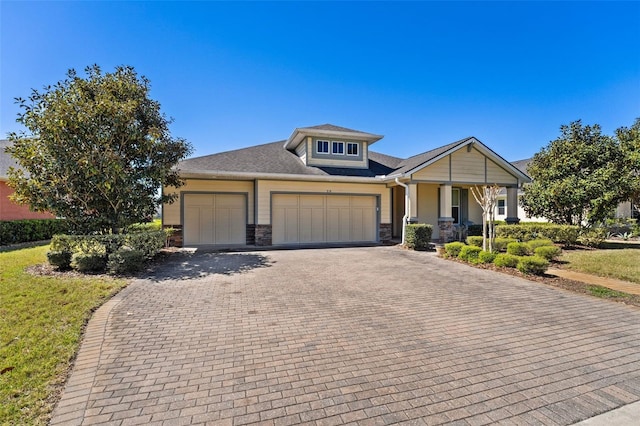 309 Chesham St, Ormond Beach, FL 32174 - view of front facade with an attached garage, decorative driveway, stone siding, and covered porch