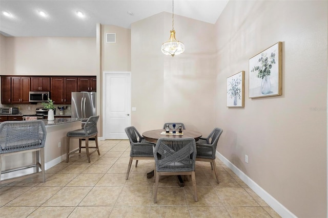 309 Chesham St, Ormond Beach, FL 32174 - dining room featuring a towering ceiling, light tile patterned floors, a chandelier, and baseboards