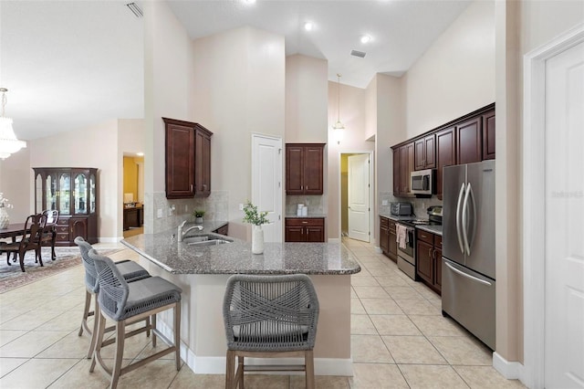309 Chesham St, Ormond Beach, FL 32174 - kitchen with stainless steel appliances, a sink, a kitchen bar, light tile patterned flooring, and backsplash