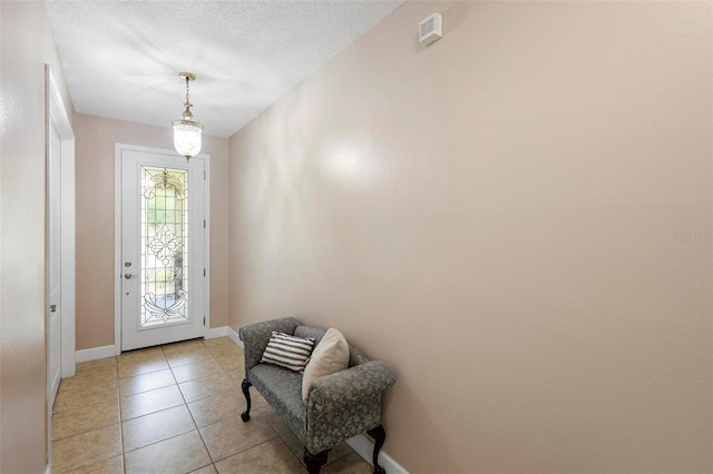 309 Chesham St, Ormond Beach, FL 32174 - doorway featuring light tile patterned flooring, baseboards, and a textured ceiling