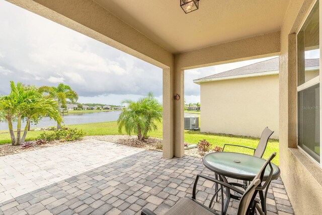 view of patio / terrace with a water view and cooling unit