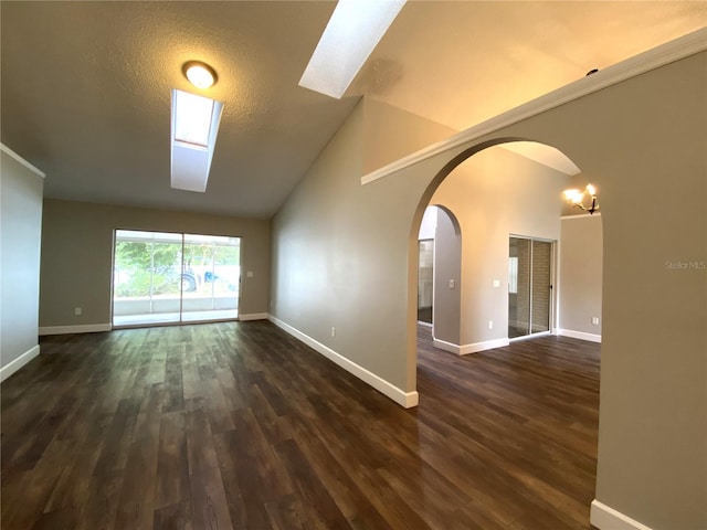 empty room with high vaulted ceiling, a textured ceiling, and dark hardwood / wood-style flooring