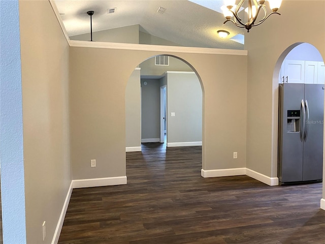 interior space with dark hardwood / wood-style flooring, stainless steel fridge with ice dispenser, pendant lighting, and vaulted ceiling