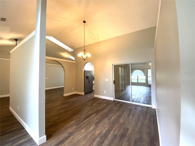 unfurnished dining area featuring a notable chandelier, dark wood-type flooring, and high vaulted ceiling