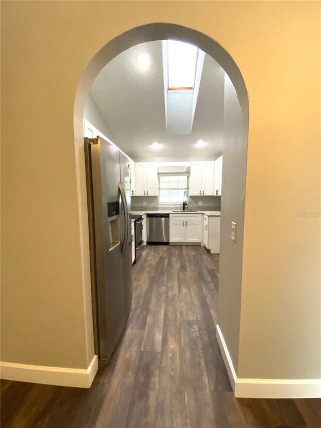 kitchen featuring stainless steel appliances, white cabinetry, dark hardwood / wood-style floors, and sink