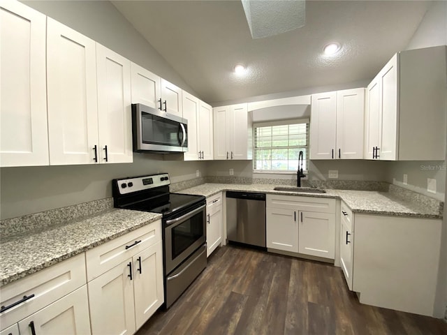 kitchen featuring white cabinetry, appliances with stainless steel finishes, sink, and light stone counters