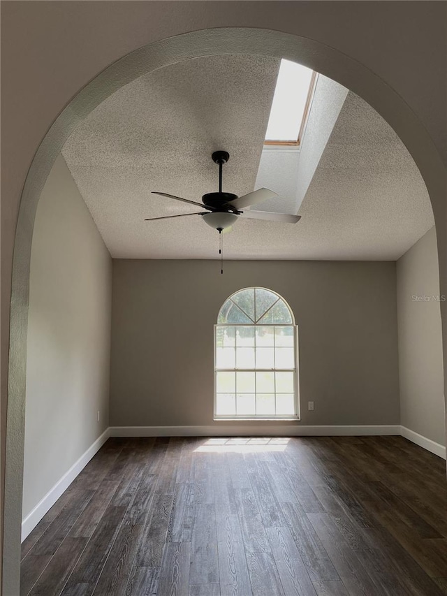 empty room featuring ceiling fan, dark hardwood / wood-style flooring, and a textured ceiling