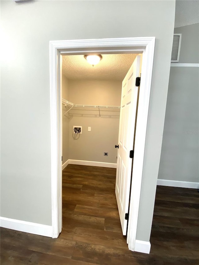 clothes washing area with washer hookup, dark wood-type flooring, and a textured ceiling