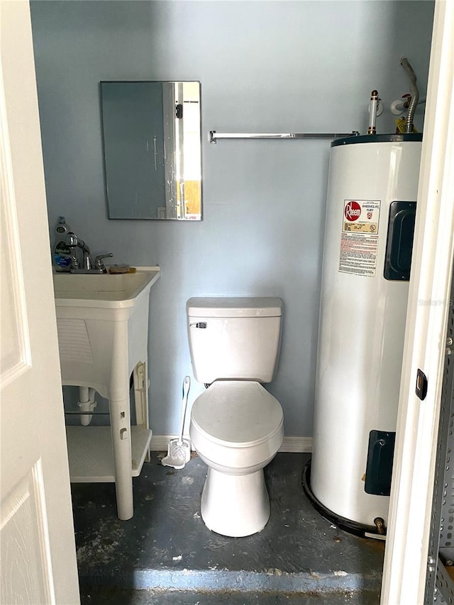 bathroom with toilet, electric water heater, and concrete floors