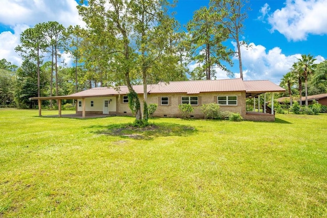 rear view of property with metal roof, crawl space, and a lawn