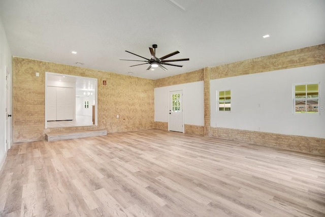 interior space featuring brick wall, light wood-type flooring, and ceiling fan