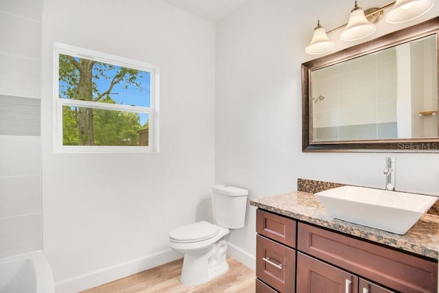 full bathroom featuring wood-type flooring, toilet, vanity, and tiled shower / bath combo