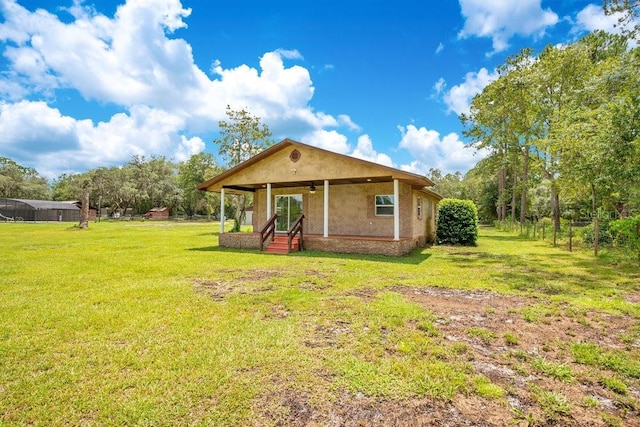 rear view of house with entry steps and a lawn