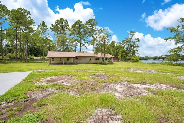 view of front of house featuring a water view and a front lawn