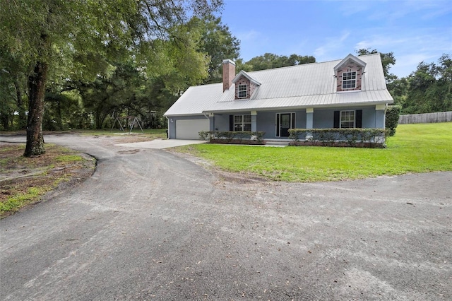 cape cod house with covered porch, a garage, and a front lawn