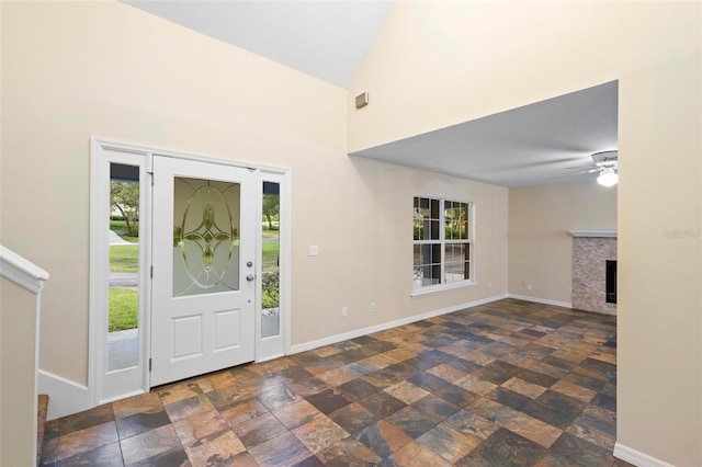 foyer entrance with lofted ceiling, ceiling fan, and a healthy amount of sunlight