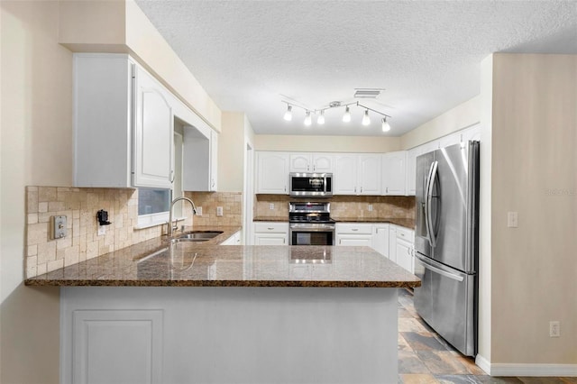 kitchen with kitchen peninsula, white cabinetry, sink, and stainless steel appliances