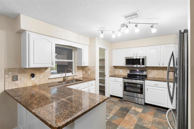 kitchen with kitchen peninsula, stainless steel appliances, white cabinetry, and sink