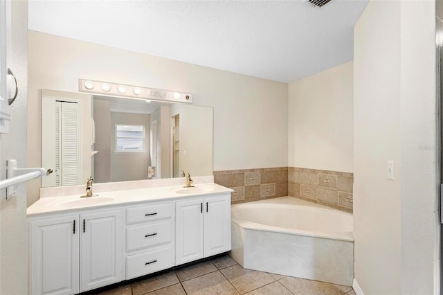 bathroom featuring tile patterned flooring, vanity, and a bathtub