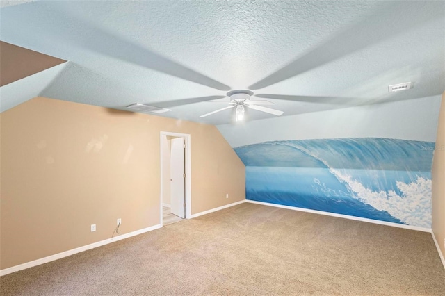 additional living space with a textured ceiling, ceiling fan, carpet flooring, and lofted ceiling