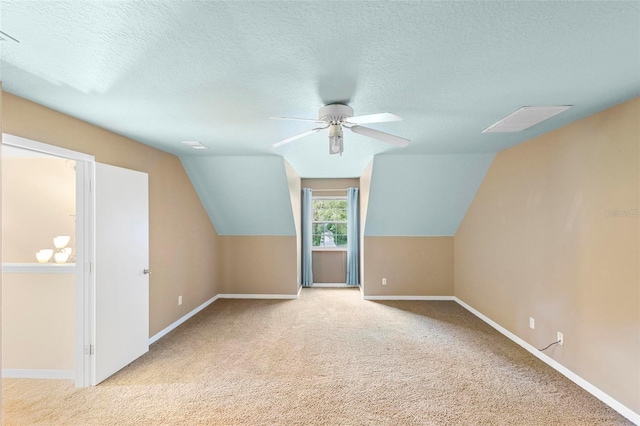 bonus room with vaulted ceiling, light carpet, ceiling fan, and a textured ceiling