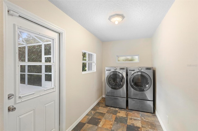 laundry room featuring washing machine and dryer and a textured ceiling