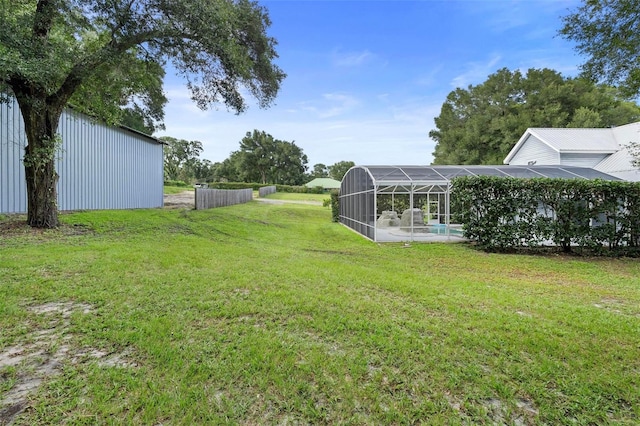 view of yard with a lanai and a swimming pool