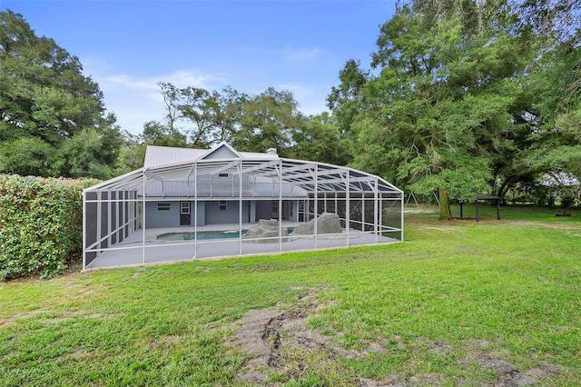 back of house with glass enclosure and a lawn