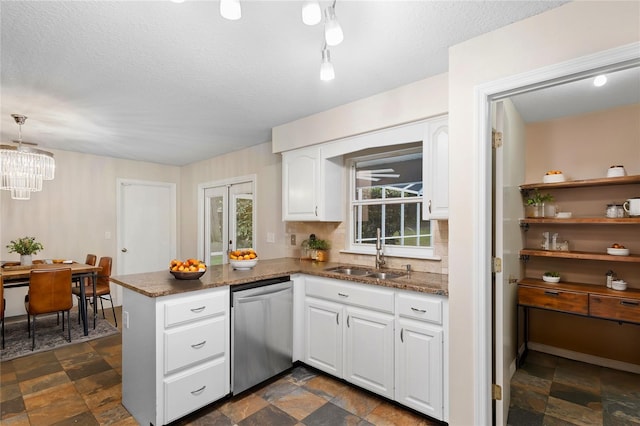 kitchen featuring sink, stainless steel dishwasher, kitchen peninsula, decorative light fixtures, and white cabinets