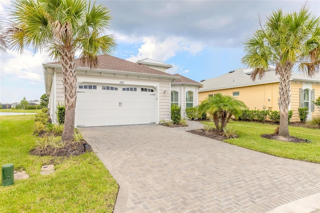 mediterranean / spanish-style house with a garage and a front yard