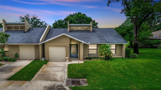 view of front of home featuring a garage and a lawn