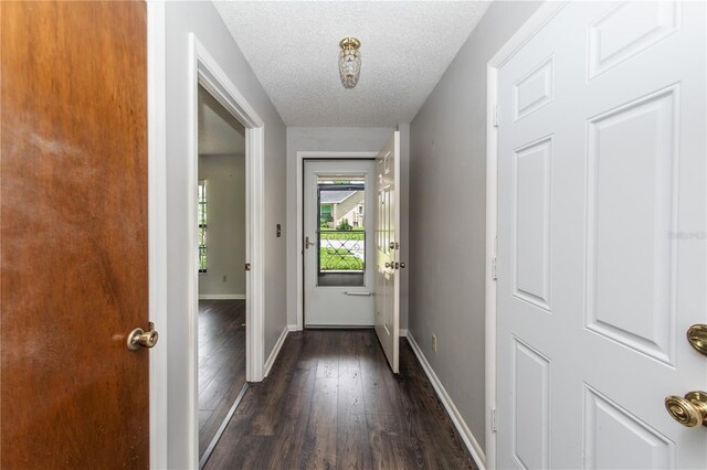 doorway with dark hardwood / wood-style flooring and a textured ceiling