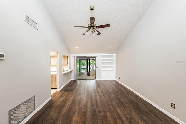 unfurnished living room featuring vaulted ceiling, a textured ceiling, dark hardwood / wood-style flooring, built in features, and ceiling fan