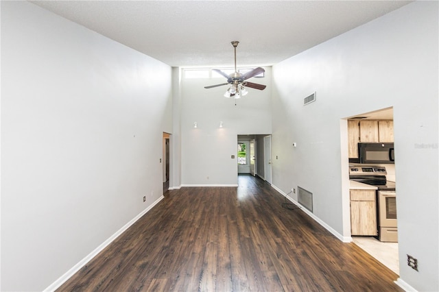 unfurnished living room featuring lofted ceiling, dark wood-type flooring, and ceiling fan