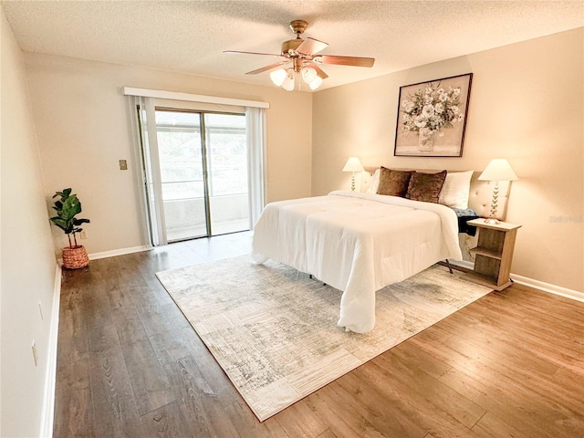 bedroom featuring ceiling fan, hardwood / wood-style floors, a textured ceiling, and access to outside