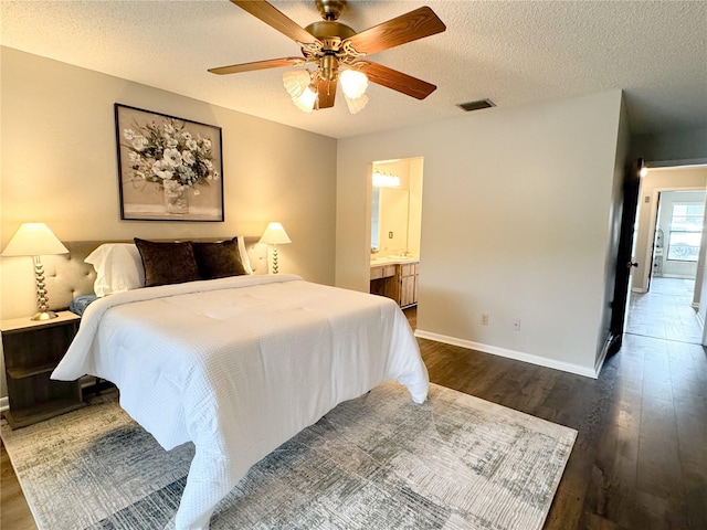 bedroom with dark hardwood / wood-style flooring, ceiling fan, and a textured ceiling