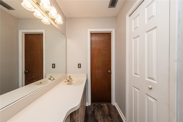 bathroom featuring wood-type flooring, a textured ceiling, and vanity