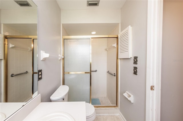 bathroom with vanity, a shower with door, and toilet