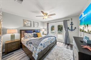 bedroom featuring light hardwood / wood-style floors, access to outside, french doors, and ceiling fan