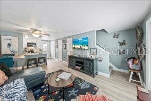 living room with light wood-type flooring and ceiling fan