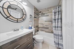 full bathroom with vanity, tile patterned flooring, toilet, and shower / bath combination with curtain