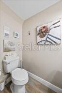 bathroom featuring hardwood / wood-style flooring and toilet