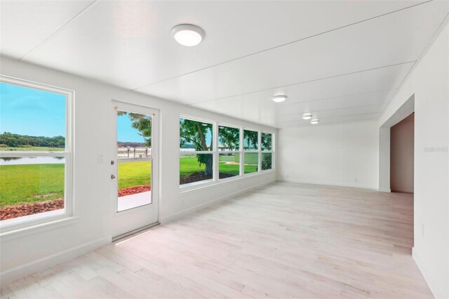 empty room with light hardwood / wood-style floors and a water view