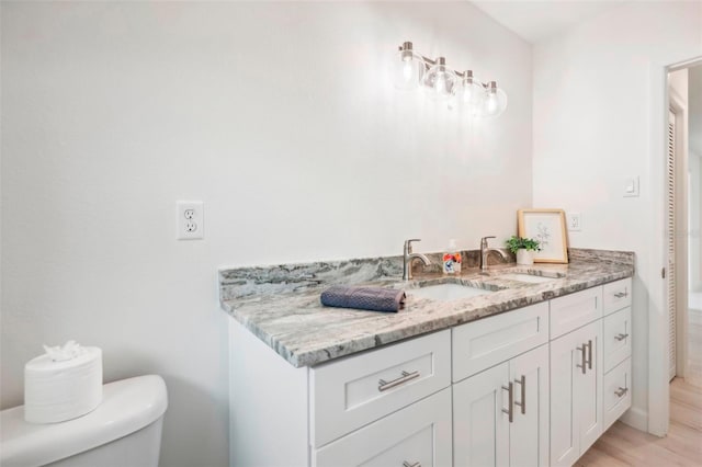 bathroom featuring vanity, hardwood / wood-style floors, and toilet